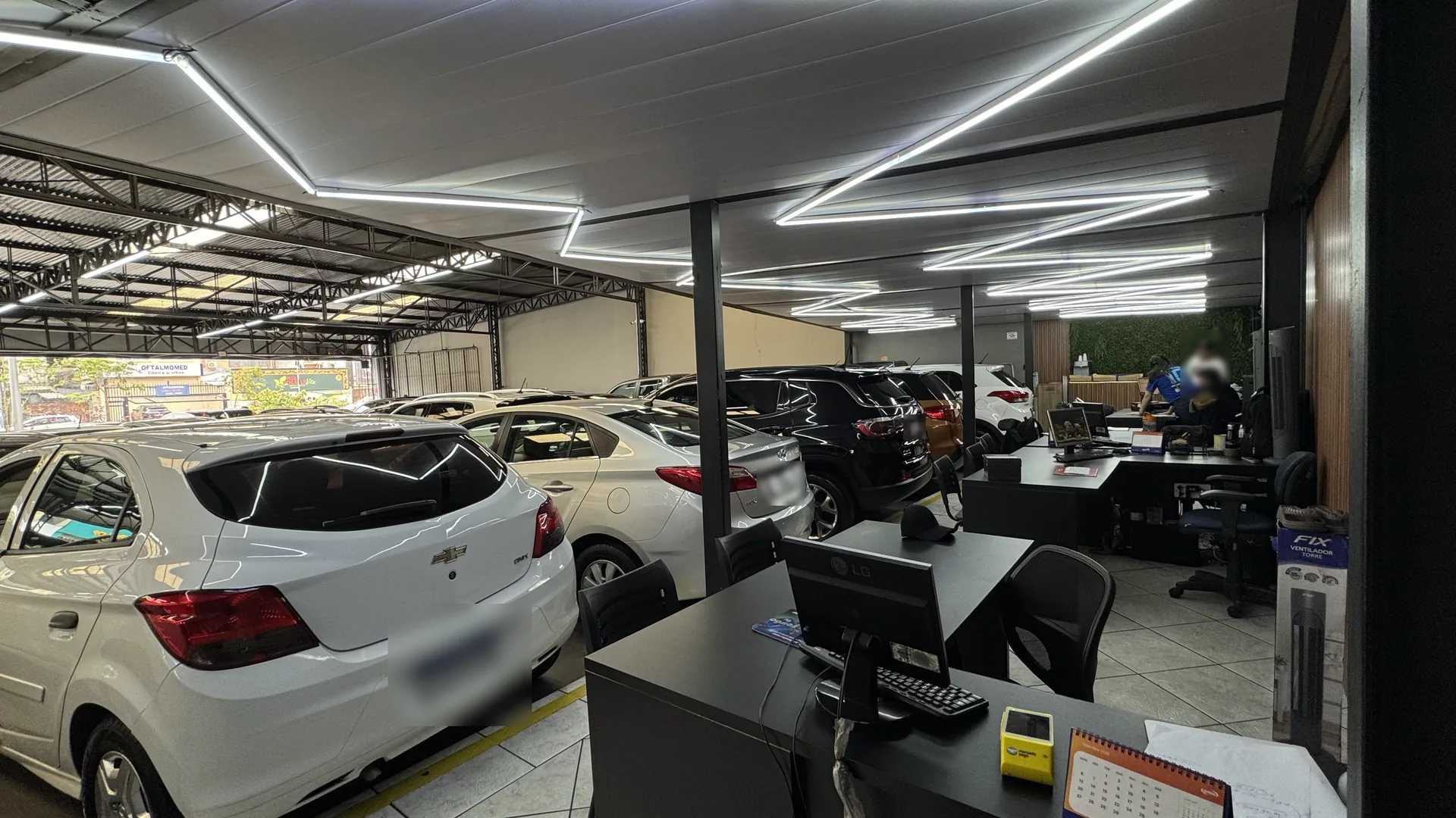 Mesas de atendimento da AutoNew ao lado dos carros